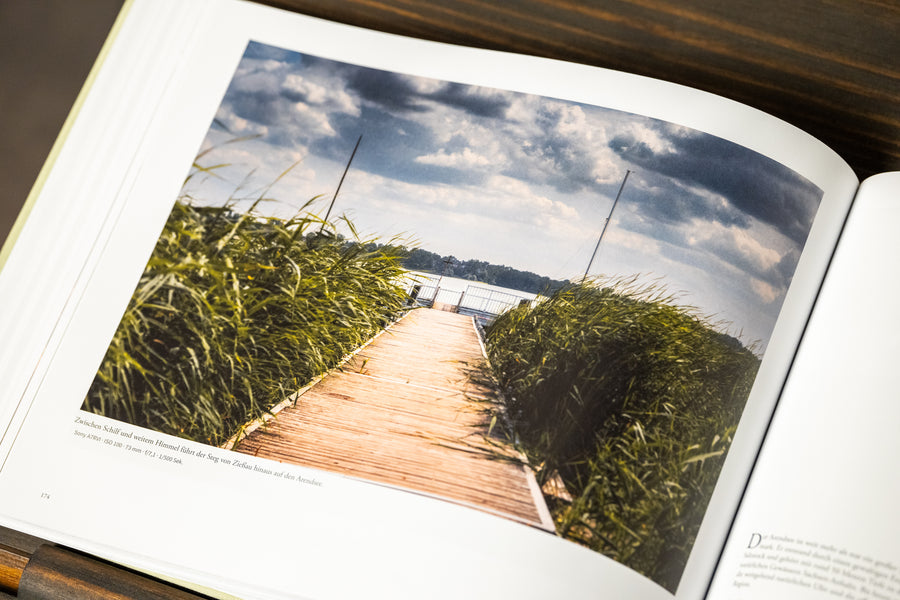 Ganzseitige Fotografie eines Stegs am Wasser im aufgeschlagenen ALTMARK Bildband.